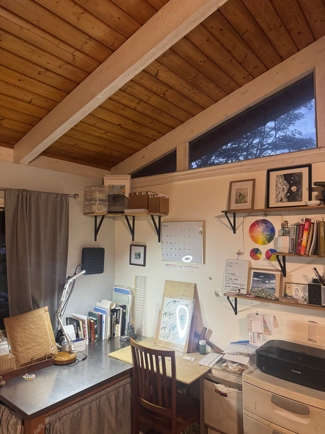 A corner art and office space with a desk, shelves and chair
